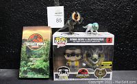 Funko POP! Dennis Nedry & Dilophosaurus 2-Pack sealed box, additional Dilophosaurus figure, and The Lost World Jurassic Park VHS in box sleeve shown together.