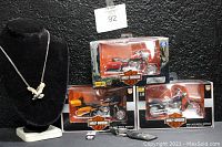 Photo of 19" two-tone Eagle necklace on black velvet bust and three sealed Maisto Harley-Davidson die-cast motorcycle replicas in original boxes, plus Indian motorcycle keychain and key.