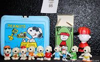Photo showing the entire lot including the blue Joe Cool lunch pail, Avon shampoo in original box, and 10 assorted vintage Snoopy figurines.