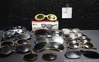 Full lot overview showing 18 pairs of sunglasses including a box of LG 3-D movie glasses, Elton John style yellow frame glasses, clip-on sunglasses, and various designer and regular sunglasses in multiple colors and styles.