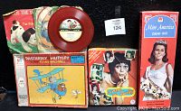 Full lot overview showing puzzles, paper doll set, and two colored vinyl records with their original sleeves.