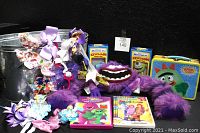 Full lot showing the Monsters Inc plush purple monster, keychains, hair clips bag, metal container, and DVDs