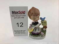 View of figurine with signage from MaxSold auction