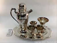 Full set on the tray including cocktail shaker, three small martini glasses, one larger martini glass, and tray.