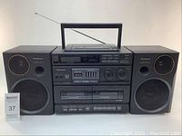 Front view of Panasonic RX-DT680 stereo with detachable speakers, showing entire system with control panel, cassette decks, and speakers.