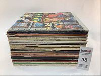 Side view of stacked vinyl records showing thickness and quantity.