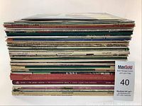 Stack view of vinyl records showing record spines with visible titles and wear on edges.