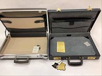 Two locking briefcases open showing interiors, keys, and instruction papers inside