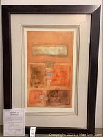 Framed abstract artwork with orange and brown blocks, artist signed on lower right, displayed with certificate of authenticity in front and frame showing slight scratches.