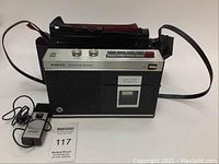 Front view of vintage Sanyo MR 410 cassette tape recorder with connected wired microphone and nearby carrying case.