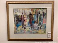 Image of the gold framed print showing a street scene with various figures dressed in coats and hats, positioned vertically on a wall.