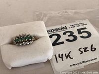 Ring displayed on white foam cushion beside MaxSold tag labeled ‘235 14K S26’.