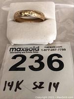 Ring on white jewelry pad with lot tag showing lot number and 14K SZ 14