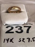 Ring on white foam block with plastic bag label showing lot number 237 and handwritten "14K sz 7.5".