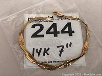 Bracelet coiled on paper with lot number card showing '14K 7"'
