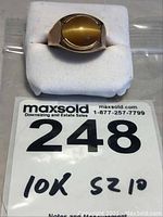 Front view of ring on white foam with MaxSold label showing lot number.