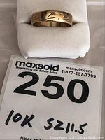 Front view of 10k gold band on white cushion showing engraving pattern and lot tag.