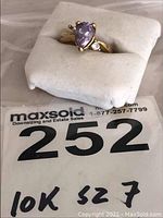 Ring displayed on white cushion with lot sticker reading “10K sz 7”