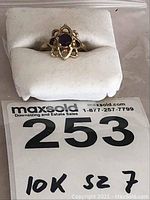 Front view of the ladies 10k gold ring with dark purple stone and size marking.