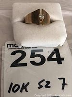 Ring on white jewelry cushion showing handwritten note “10K S2 7”