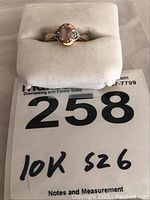 Full view of the ladies 10k gold ring placed on a white ring holder with the label indicating 10k gold and size 6.