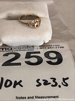 Side and front close-up of the 10k gold ring showing the raised letter 'P' and leaf pattern design on the band