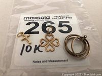 Photo of all three 10k gold charms together on a MaxSold card labeled with lot number and gold purity.