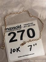 Image showing 7 inch 10k gold bracelet laid flat with MaxSold tag indicating '10K 7"'.