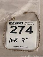 Full view of 9-inch 10k gold ladies bracelet with spring clasp attached, displayed on a plastic MaxSold bag with lot number 274 and description.