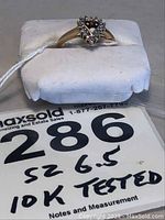 Front view of ladies 10k gold ring size 6.5 with heart-shaped diamond cluster design on white display pad with MaxSold tag