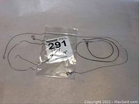 Three sterling silver neck chains laid out on surface with clear plastic bag marked 291.
