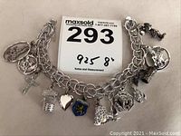 Full view of the sterling silver 8-inch charm bracelet with all attached charms shown spread out.