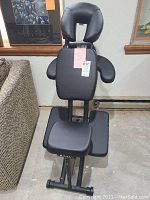 Full view of Oakworks Portal Pro 3 massage chair showing face cradle, arm rests, chest and leg rests with black padding mounted on black metal frame.