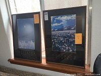 Both framed Colorado landscape art prints, 'Winter' and 'Spring', shown standing side by side on a window sill.