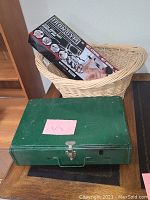 Photo showing the Iron Gym box inside the wicker basket plus the closed green Coleman camp stove in front