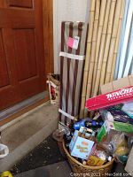 Full view of the closed canopy carrying case upright beside a door with surrounding miscellaneous items.