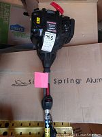 Full view of the black and red Troy-Bilt 4 cycle gas engine, labeled TB6044, with attached shaft.