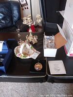 Full lot on black tables showing floral basket, candelabras, and Christmas ornaments
