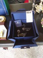 Pair of clear Swarovski swan figurines in blue velvet box with certificate and card inside box.