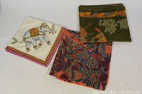 Three silk tablecloths displayed together showing variety in colors and patterns.