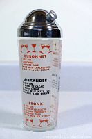 Photo of the shaker showing recipes for Dubonnet, Alexander, Bronx cocktails printed in red text on frosted glass with chrome lid on top.