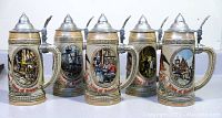 Set of five Budweiser ceramic beer mugs with metal lids, arranged side by side showing front scenes and handles