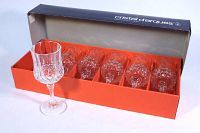 Photo showing six Cristal D'arques large wine glasses in original orange box with one glass standing upright outside the box.