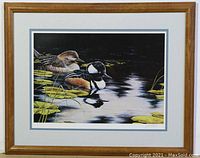 Framed print showing entire artwork with wooden frame and double matting; depicts two Hooded Mergansers resting on water with water lilies