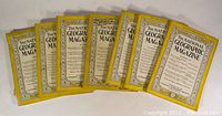 Seven National Geographic magazines arranged horizontally, showing front covers with yellow borders.