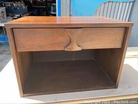 Front view of the Kroehler small side table showing drawer and open storage shelf, wood surface visible with some wear.
