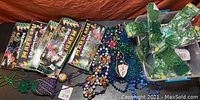 Photo showing multiple unopened boxes of Mardi Gras 50 Mini Lights along with assorted bead necklaces on a table.