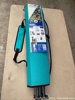 Folding canopy chair in carrying bag turquoise color with packaging indicating features and brand.