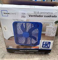 Blue box fan in open box, showing box front with fan image and product details in Spanish.