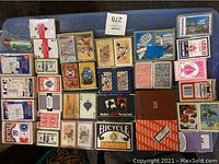 Overview of the full playing card collection laid out on table showing the variety of card backs and box designs.